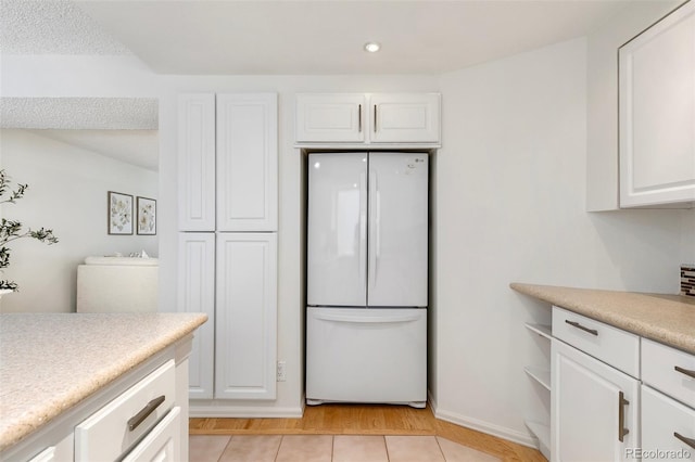 2049 Sussex Ln, Colorado Springs, CO 80909 - kitchen with freestanding refrigerator, white cabinets, light countertops, recessed lighting, and light tile patterned flooring