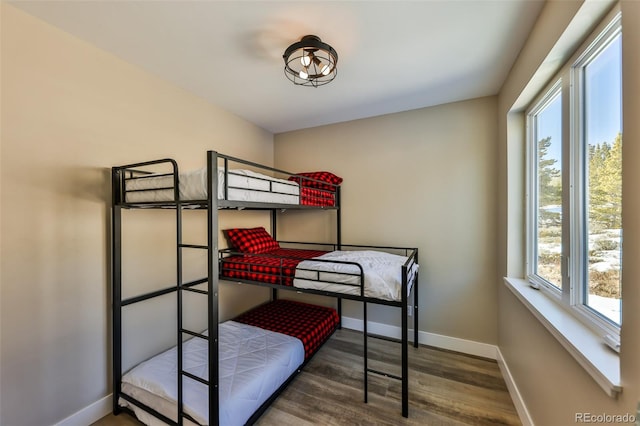 bedroom with wood finished floors and baseboards