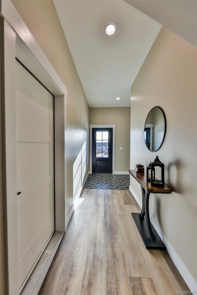 foyer entrance with recessed lighting, light wood-type flooring, and baseboards