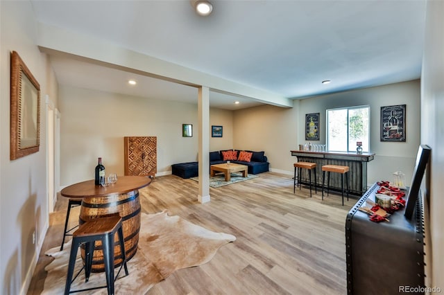 living area with recessed lighting, baseboards, a dry bar, and wood finished floors