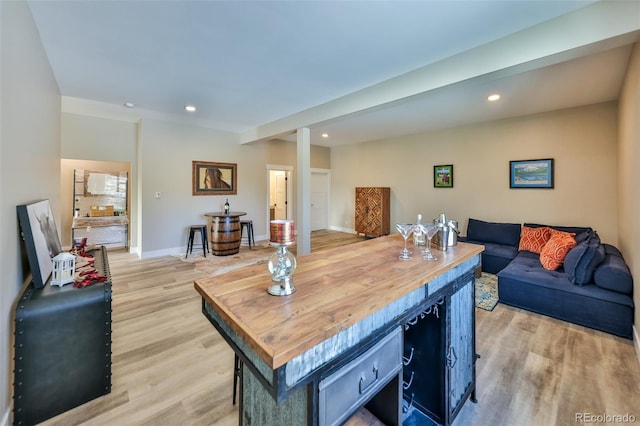 living area featuring baseboards, light wood finished floors, and recessed lighting