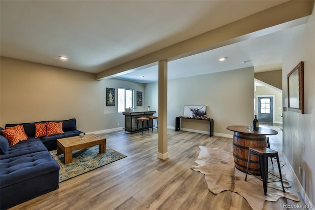 living area with baseboards, wood finished floors, and recessed lighting