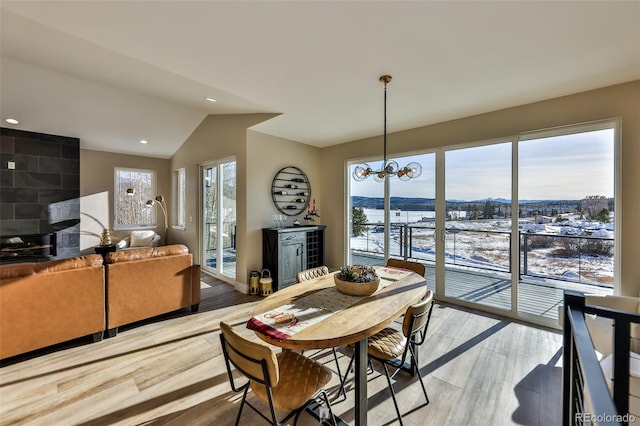 dining area with vaulted ceiling, recessed lighting, an inviting chandelier, and light wood-style floors