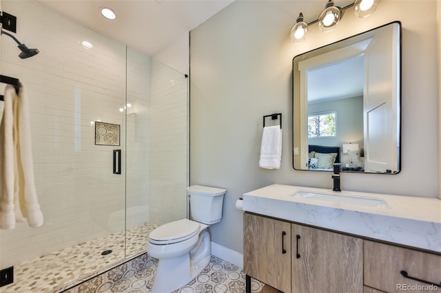 full bath with toilet, ensuite bathroom, a stall shower, vanity, and tile patterned floors