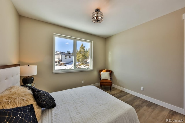 bedroom with wood finished floors and baseboards