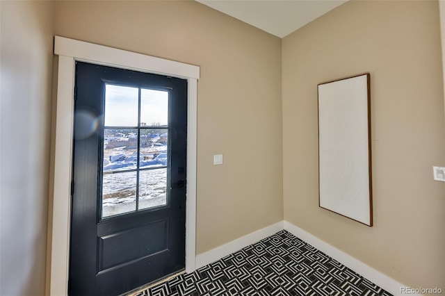 doorway to outside featuring baseboards