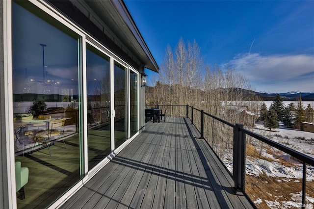 snow covered back of property featuring a mountain view