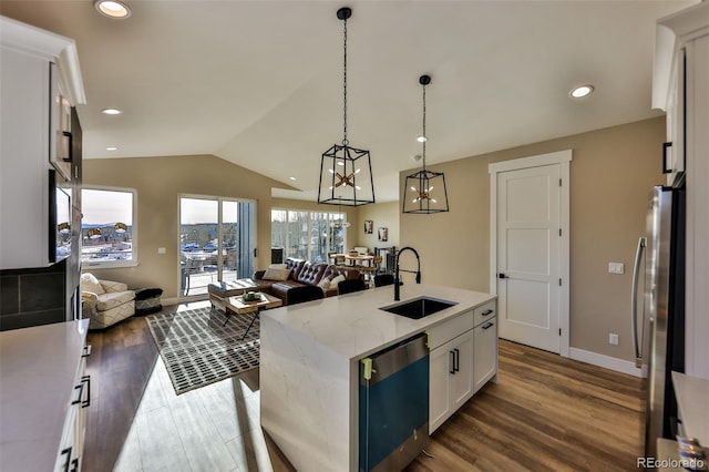 kitchen featuring freestanding refrigerator, open floor plan, a sink, and lofted ceiling