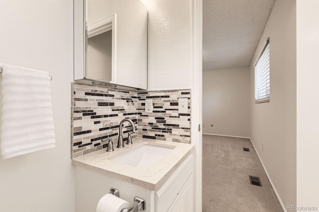 6348 S Independence St, Littleton, CO 80123 - bathroom with backsplash, vanity, and a textured ceiling