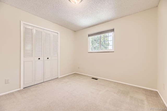 6348 S Independence St, Littleton, CO 80123 - unfurnished bedroom featuring light carpet, a closet, and a textured ceiling