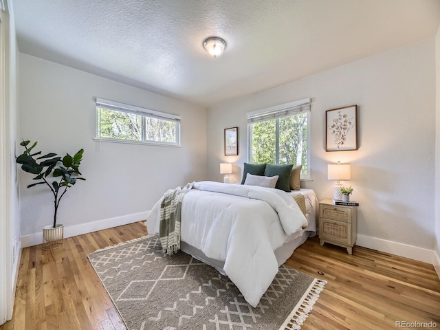 50 Yarrow St, Lakewood, CO 80226 - bedroom featuring baseboards, light wood finished floors, and a textured ceiling