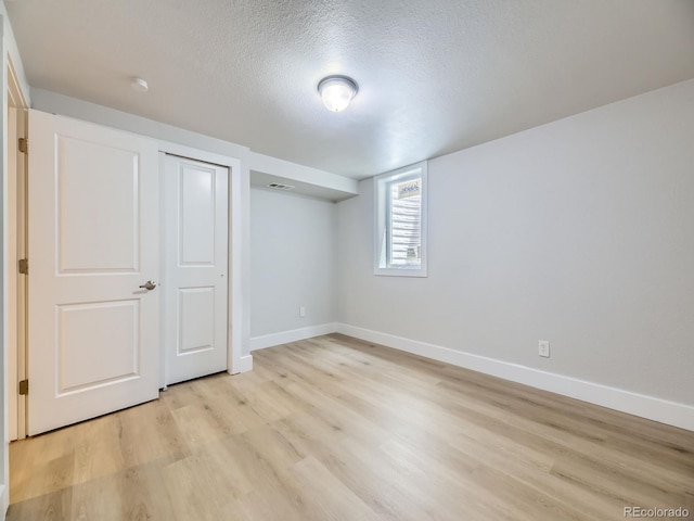50 Yarrow St, Lakewood, CO 80226 - basement with a textured ceiling, baseboards, and light wood-style floors
