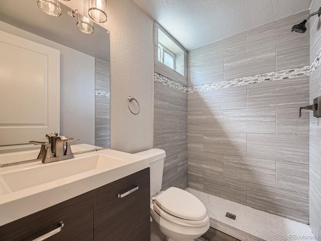 50 Yarrow St, Lakewood, CO 80226 - full bath featuring a tile shower, vanity, toilet, and a textured ceiling