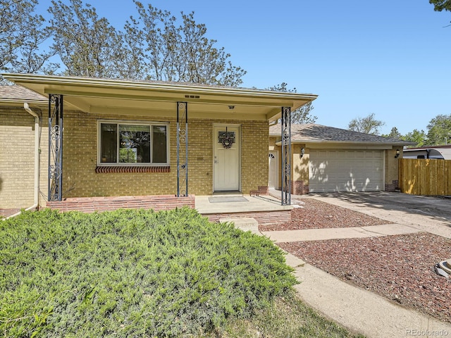 50 Yarrow St, Lakewood, CO 80226 - single story home with brick siding, concrete driveway, and an attached garage