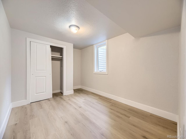 50 Yarrow St, Lakewood, CO 80226 - unfurnished bedroom featuring light wood-type flooring, a textured ceiling, baseboards, and a closet
