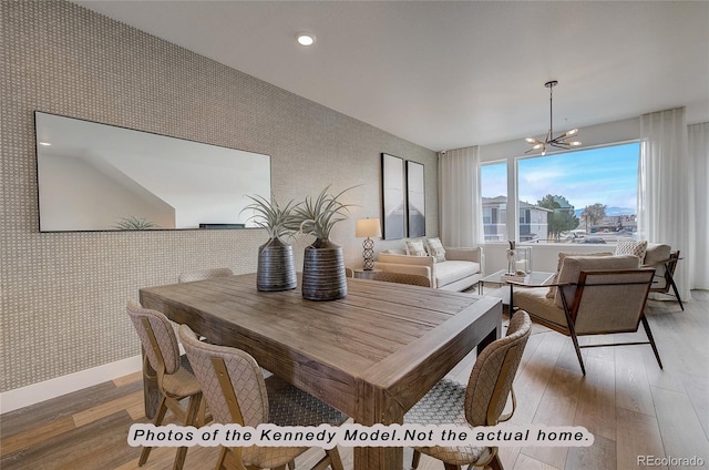 dining space featuring hardwood / wood-style flooring and a chandelier