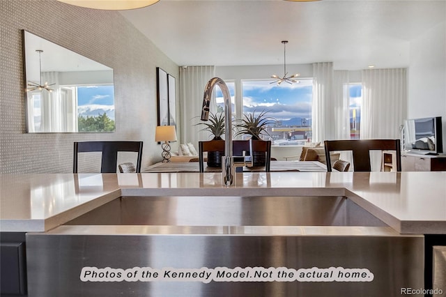 kitchen featuring a healthy amount of sunlight, sink, and an inviting chandelier