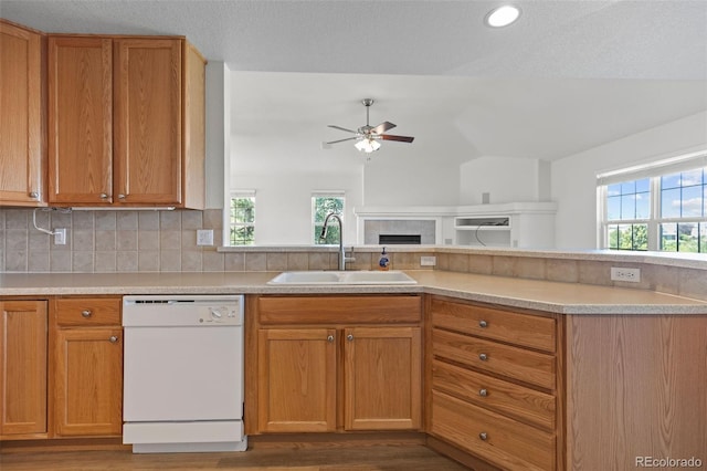 7713 S Zante Ct, Aurora, CO 80016 - kitchen featuring white dishwasher, ceiling fan, light countertops, a fireplace, and wood finished floors