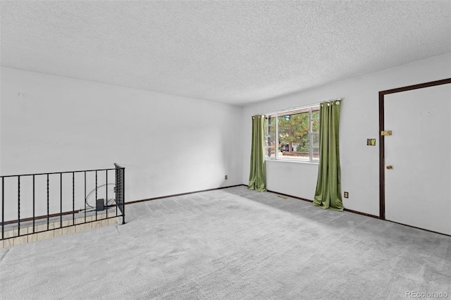 carpeted spare room featuring a textured ceiling