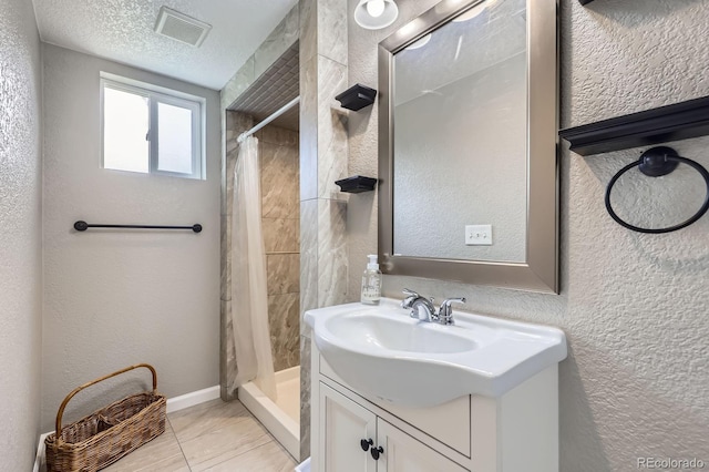 3378 Mowry Pl, Westminster, CO 80031 - bathroom featuring vanity, a shower stall, a textured wall, and baseboards