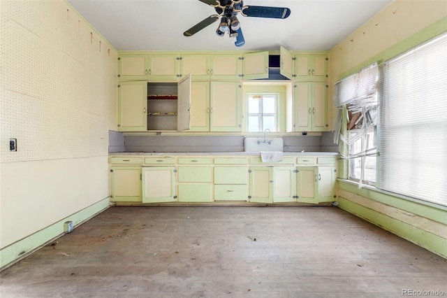 kitchen with open shelves, light wood-style flooring, cream cabinetry, and a wealth of natural light