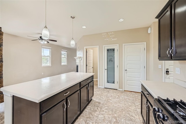 kitchen with ceiling fan, stainless steel range with gas stovetop, dark brown cabinetry, and decorative light fixtures