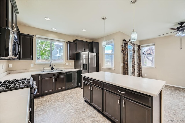 kitchen featuring pendant lighting, sink, appliances with stainless steel finishes, dark brown cabinets, and a center island