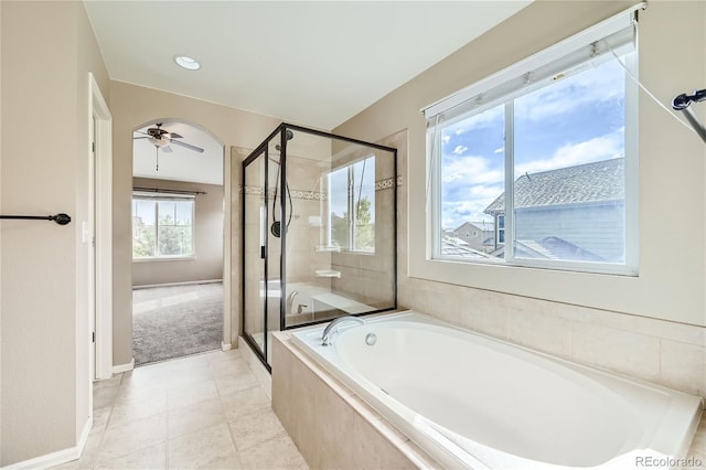 bathroom featuring ceiling fan and plus walk in shower