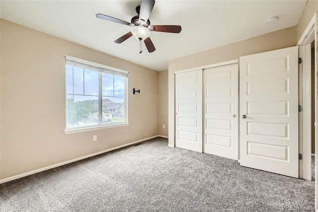 unfurnished bedroom featuring ceiling fan, carpet flooring, and a closet