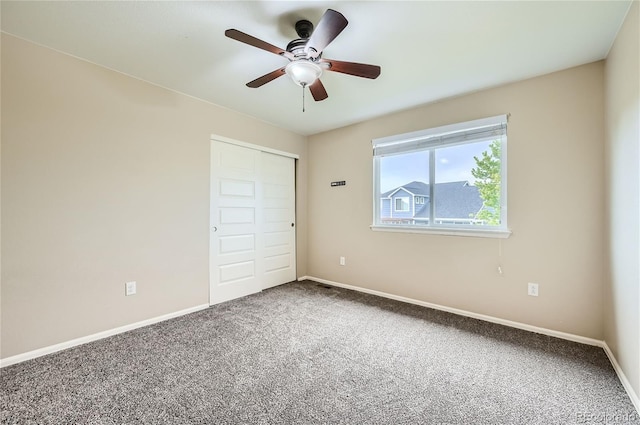 unfurnished bedroom with ceiling fan, carpet, and a closet