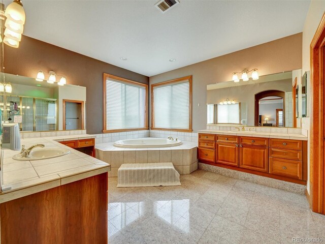 6533 S Quemoy Way, Aurora, CO 80016 - bathroom featuring a garden tub, a stall shower, granite finish floor, a sink, and visible vents