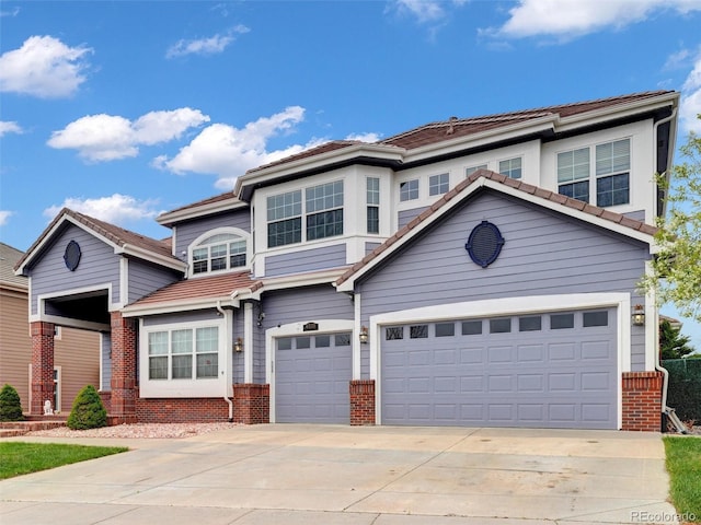 6533 S Quemoy Way, Aurora, CO 80016 - view of front of home with a tile roof, a garage, brick siding, and driveway