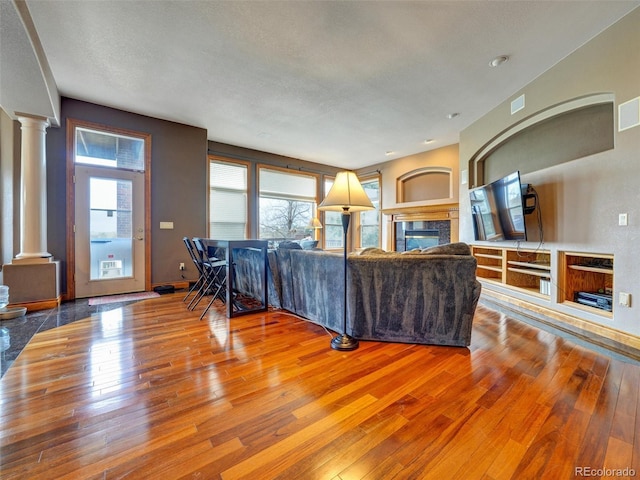 6533 S Quemoy Way, Aurora, CO 80016 - living room with hardwood / wood-style floors, ornate columns, plenty of natural light, and visible vents