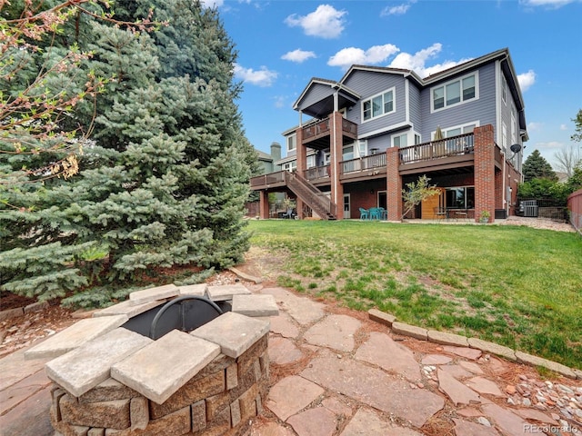 6533 S Quemoy Way, Aurora, CO 80016 - back of house featuring a lawn, central AC, stairs, a deck, and a fire pit
