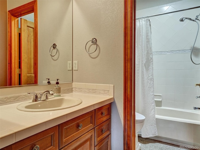 6533 S Quemoy Way, Aurora, CO 80016 - bathroom featuring toilet, vanity, shower / tub combo, and a textured wall