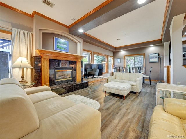 6533 S Quemoy Way, Aurora, CO 80016 - living room featuring wood finished floors, ornamental molding, visible vents, a premium fireplace, and baseboards
