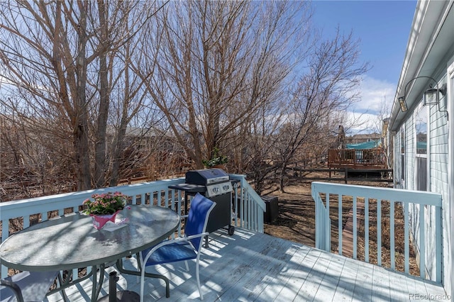 wooden deck featuring outdoor dining space and area for grilling