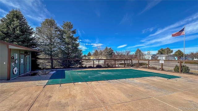 pool with a patio area and fence