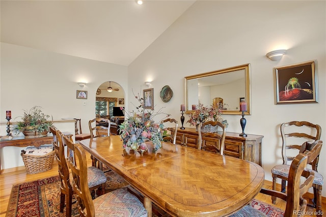 dining room with wood finished floors and high vaulted ceiling