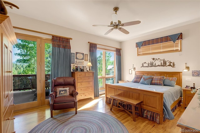 bedroom featuring a baseboard heating unit, light wood-style flooring, access to exterior, and a ceiling fan