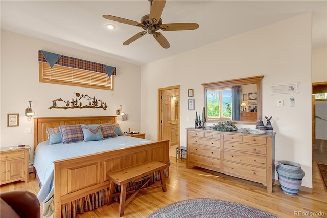 bedroom featuring light wood finished floors, connected bathroom, a ceiling fan, and recessed lighting