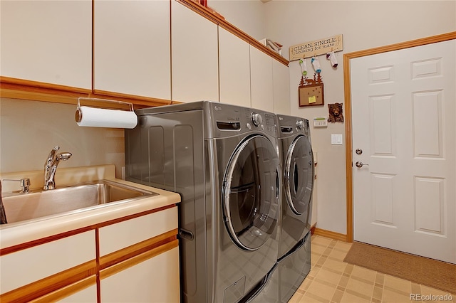 washroom with washer and dryer, a sink, light floors, and cabinet space