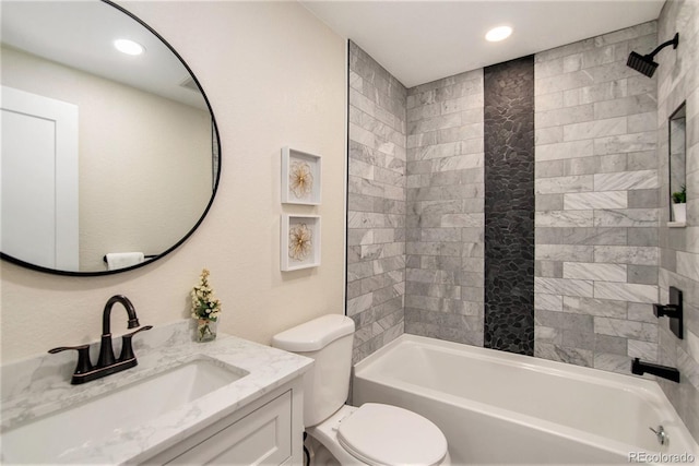 full bathroom featuring vanity, toilet, and tiled shower / bath