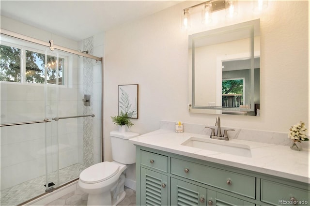 bathroom featuring a shower with door, vanity, and toilet