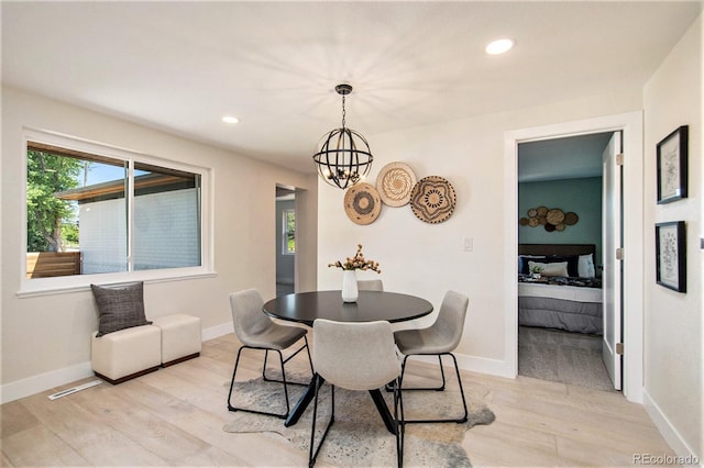 dining room with light wood-type flooring and an inviting chandelier