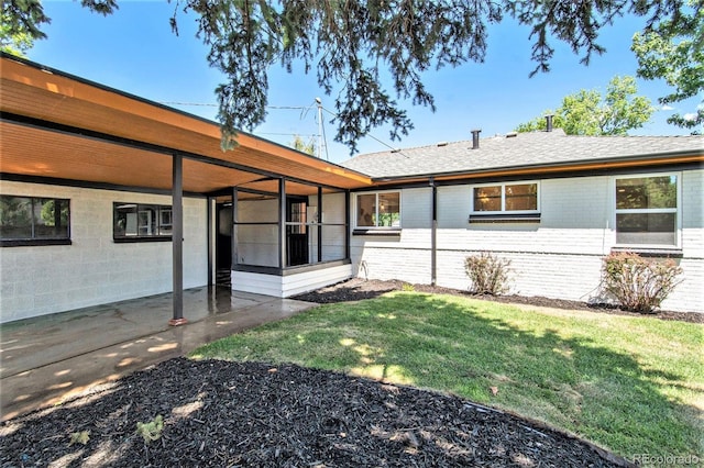 rear view of property featuring a lawn