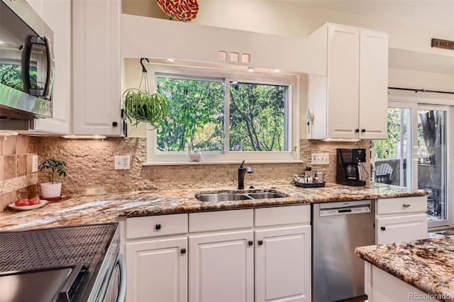 kitchen with appliances with stainless steel finishes, white cabinets, and sink