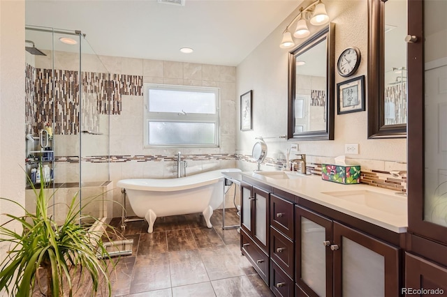 bathroom featuring vanity, independent shower and bath, tile patterned floors, and tile walls