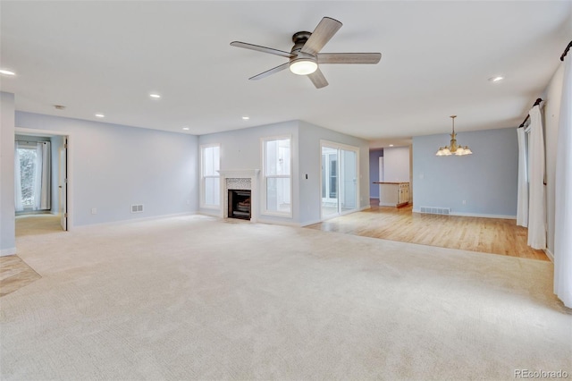 20 Scott Dr, Broomfield, CO 80020 - unfurnished living room with light colored carpet, a chandelier, a fireplace with flush hearth, baseboards, and recessed lighting