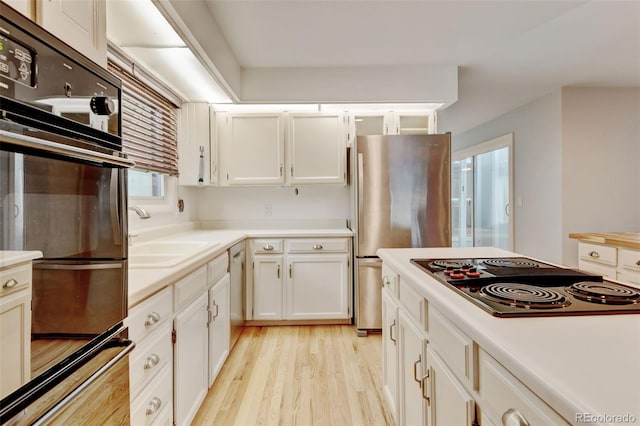 20 Scott Dr, Broomfield, CO 80020 - kitchen featuring electric cooktop, a sink, freestanding refrigerator, light wood finished floors, and white cabinets